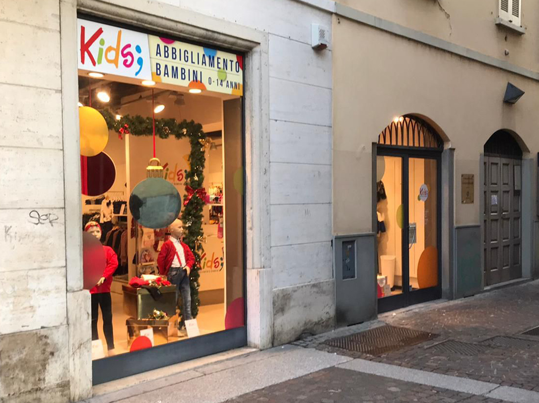 Negozio Kids; in via roma con vetrofanie personalizzate creative.